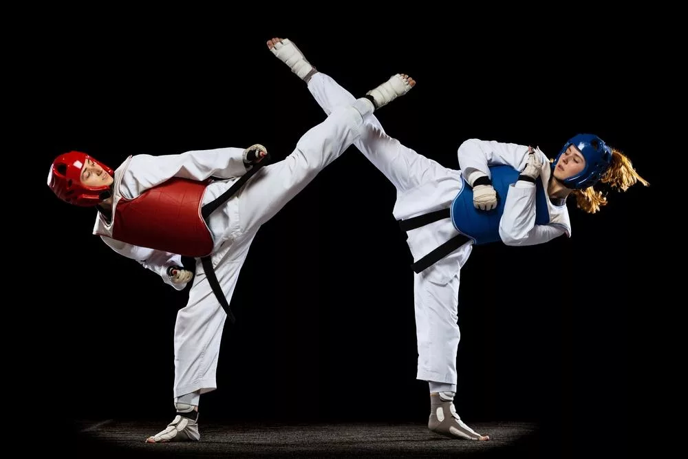 2 taekwondo fighters throwing kicks